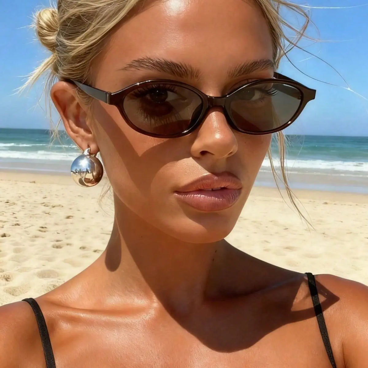 Vrouw aan zee met de Isa ovale zonnebril in bruin